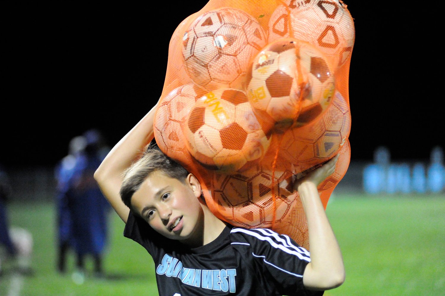 Jack of all trades. Landen Boyd, one of Sullivan West’s up and coming freshman booters, rounds up the team’s soccer balls after the match.